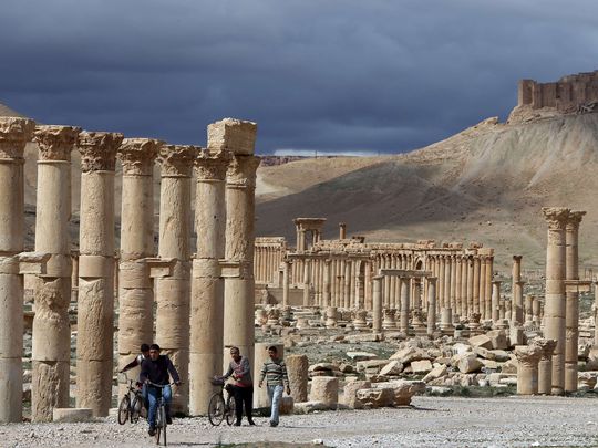 People ride bicycles near ruins in the ancient city in this photo from 2014. (Photo: Joseph Eid, AFP/Getty Images)