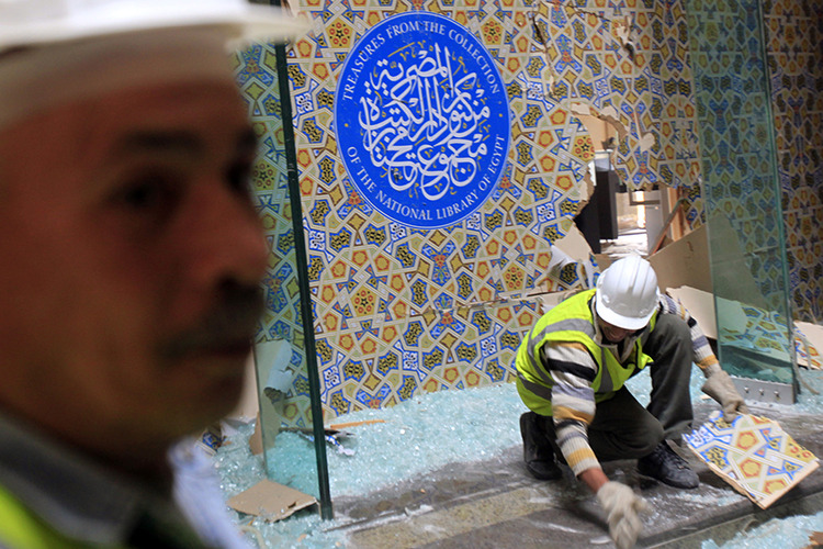 An antiquities restoration worker removes glass at the Egyptian National Library and Archives, which was damaged by a car bomb attack targeting the nearby Cairo Security Directorate on Friday, in downtown Cairo January 26, 2014. Egypt will hold a presidential vote before electing parliament, President Adly Mansour said on Sunday, reneging on a roadmap and increasing the likelihood that army chief General Abdel Fattah al-Sisi will be elected as head of state within months. Parliamentary elections were supposed to happen first under the timetable agreed after the army deposed Islamist President Mohamed Mursi in July following mass protests against his rule. REUTERS/Amr Abdallah Dalsh (EGYPT - Tags: POLITICS CIVIL UNREST) - RTX17V6M