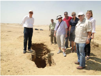 Looting pit at Saqqara. L-R: Peter Herdrich, Chief Executive Officer AIA; State Antiquities Official; Sarah Parcak Founding Director, Laboratory for Global Observation; State Antiquities Official; Deborah Lehr, Chairman, CAI; Theodore S. Greenberg, Senior Advisor, CAI; Claire Buchan, and Senior Advisor, CAI. Photo courtesy Eric Cline, Director, Capitol Archaeological Institute (CAI).