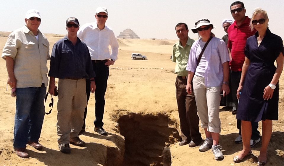 ICPEA members (from left) Ted Greenberg, Eric Cline, Peter Herdrich, driver, Sarah Parcak, security, and Deborah Lehr examine a looters pit in Saqqara. Copyright Peter Herdrich